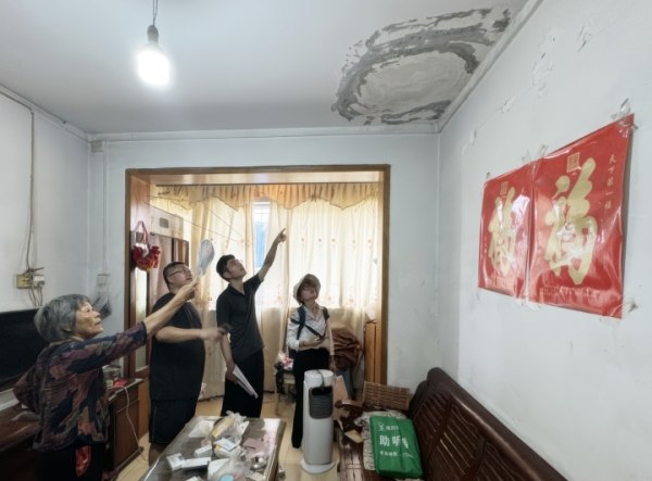 九龍坡區(qū)審計局工作人員走進居民家中，了解老舊小區(qū)改造情況。九龍坡區(qū)審計局供圖