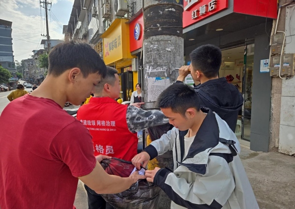 網(wǎng)格力量上街清掃集鎮(zhèn)牛皮癬。紅獅鎮(zhèn)供圖