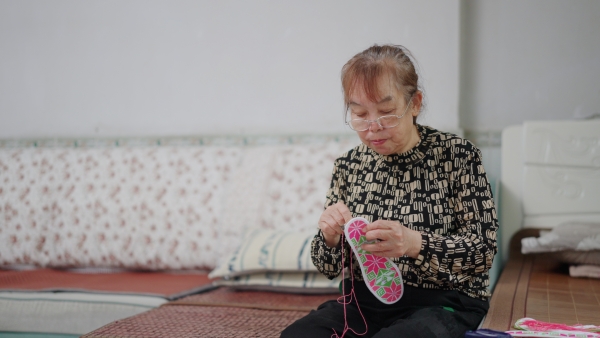 張興會(huì)縫制鞋墊。大足區(qū)委宣傳部供圖