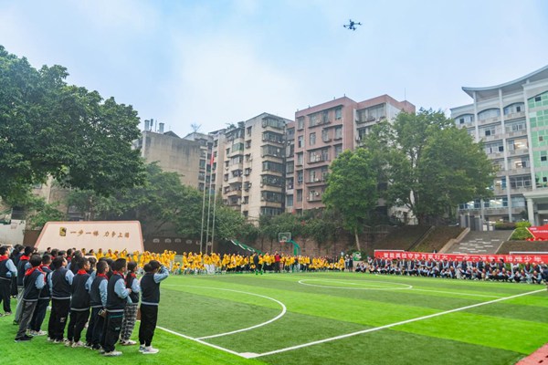何濤在上游小學(xué)足球場為學(xué)生們演示無人機(jī)操作。國網(wǎng)重慶永川供電公司供圖