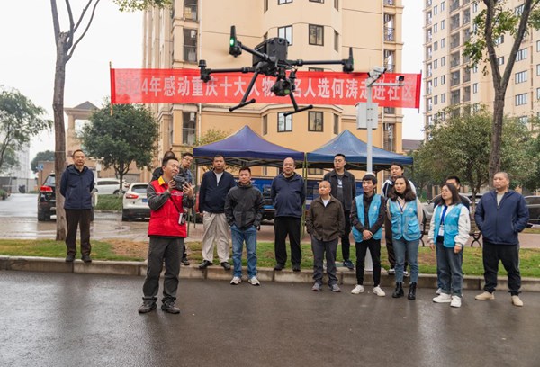 何濤在鳳凰麗苑小區(qū)向群眾展示無人機(jī)巡檢技術(shù)。國網(wǎng)重慶永川供電公司供圖
