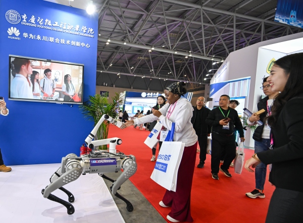 參會嘉賓與足臂協(xié)同機器人互動。重慶智能工程職業(yè)學(xué)院供圖