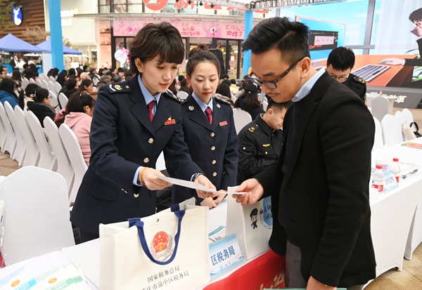 12月3日，渝中區(qū)稅務局聯合區(qū)司法局走進龍湖時代天街開展憲法宣傳活動，發(fā)放宣傳資料、解答涉稅費問題。徐佑君攝