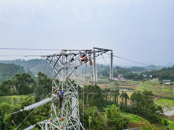 電力工人在距地40米高的輸電鐵塔上作業(yè)。國網(wǎng)重慶永川供電公司供圖