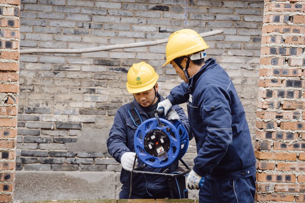 電力人員檢查供電線路并牽線入戶。國網(wǎng)重慶永川供電公司供圖
