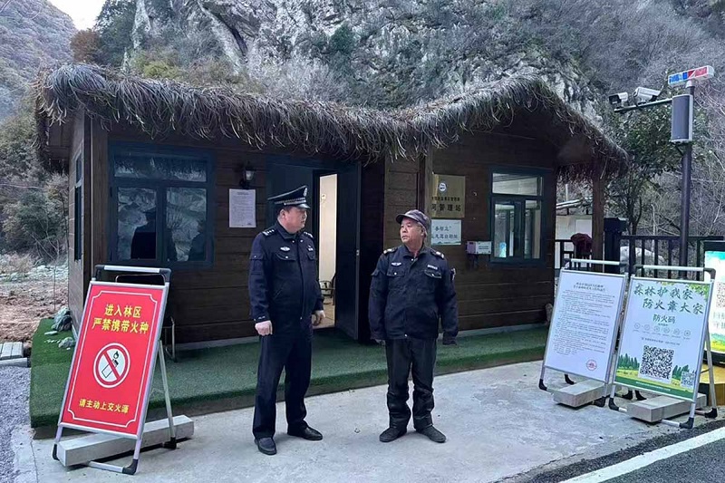 溫軍文（左）在和秦嶺聯(lián)防的民間工作人員交談。李凱攝