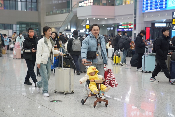 重慶火車北站候車廳內(nèi)，旅客帶著行李踏上回家路。汪亮攝
