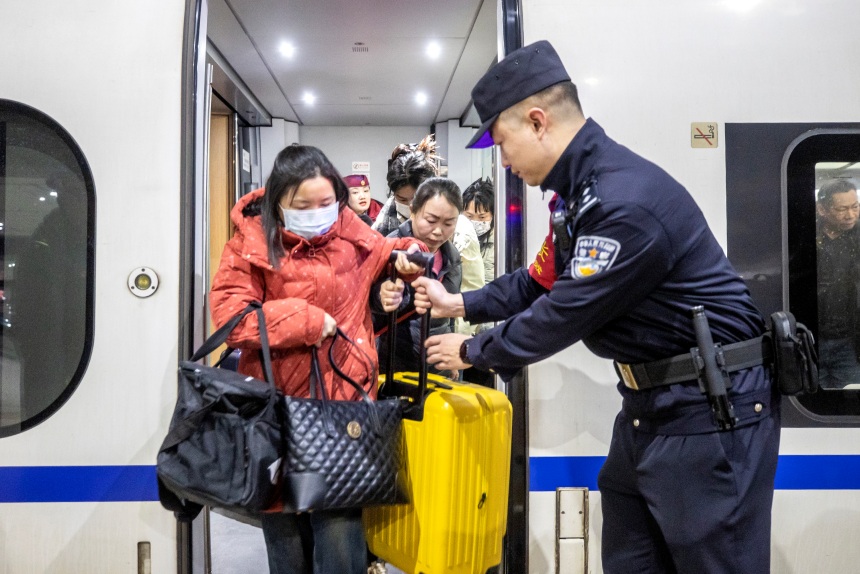 1月21日，G4616次列車抵達(dá)重慶西站后，乘警李鎮(zhèn)在車門處引導(dǎo)旅客有序下車。胡勇攝