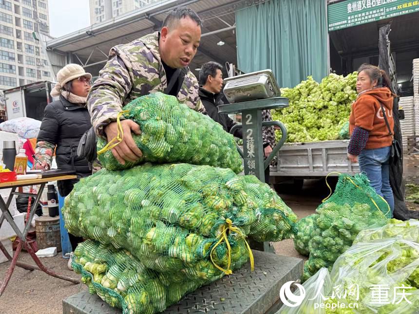 采購(gòu)商正將采購(gòu)的“兒菜”過秤。人民網(wǎng)記者 胡虹攝