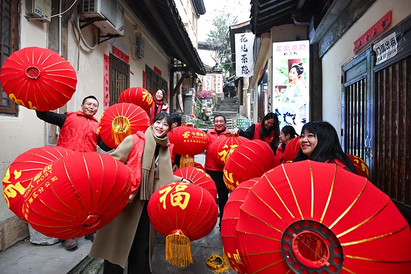 志愿者們?yōu)辄S葛古道敦厚坡老街的傳統(tǒng)民居掛燈籠。郭旭攝