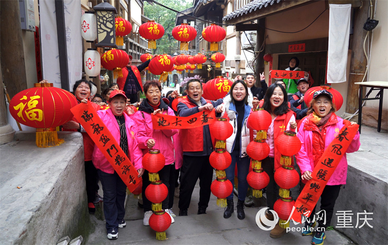 志愿者們?yōu)辄S葛古道敦厚坡老街的傳統(tǒng)民居貼春聯(lián)。人民網(wǎng)記者 劉祎攝 