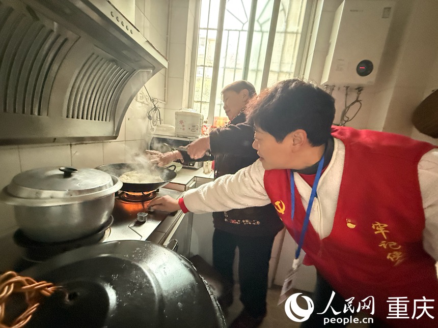入戶(hù)走訪時(shí)，岳嬢嬢正在做飯，文登群趕緊去廚房調(diào)小燃?xì)庠畹幕?。人民網(wǎng)記者 胡虹攝