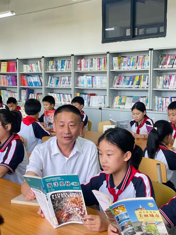 顏林在閱覽室與學(xué)生閱讀。梁平區(qū)委宣傳部供圖