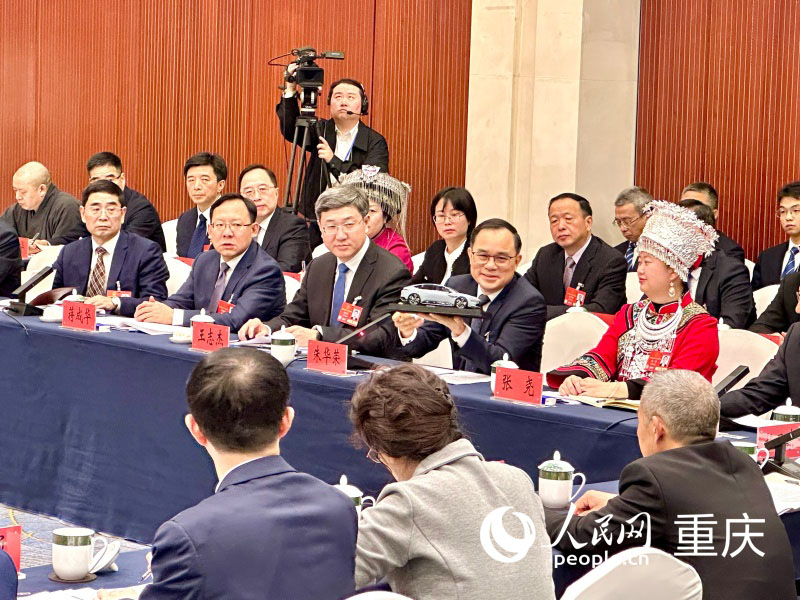 2025全國兩會期間，朱華榮在重慶代表團開放團組會議上展示“重慶造”汽車模型。人民網(wǎng)記者 劉政寧攝