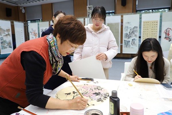 老同志現(xiàn)場(chǎng)作畫，在職職工鑒賞學(xué)習(xí)。國網(wǎng)重慶永川供電公司供圖