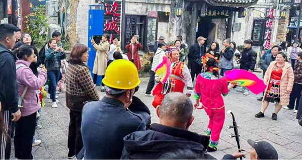 游客在洪安邊城旅游區(qū)觀看秀山花燈表演。姚華勝攝