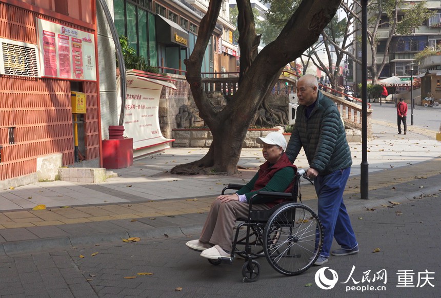 涂安全推著徐紅在社區(qū)散步。人民網(wǎng)記者 劉祎攝