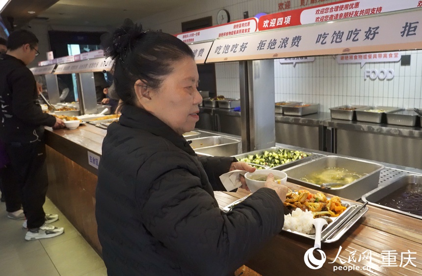 彭其碧在社區(qū)食堂打飯。人民網(wǎng)記者 劉祎攝