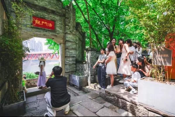 游客們?cè)跇?biāo)志性景點(diǎn)拍照。龍門浩老街供圖