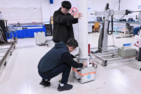 研究生們演示實(shí)驗(yàn)儀器。主辦方供圖